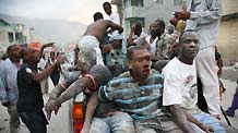 Injured people are transferred for treatment after a powerful earthquake on a street of Haiti's capital Port-au-Prince on January 12, 2010.