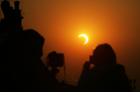 Tourists take photo of the eclipse at the Temple of Heaven in Beijing, capital of China, Jan. 15, 2010. (Xinhua/Zheng Huansong)