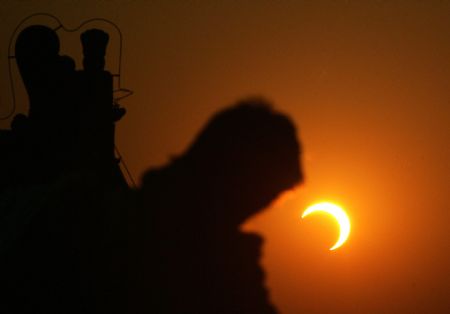 A photographer takes photo of the eclipse at the Temple of Heaven in Beijing, capital of China, Jan. 15, 2010. (Xinhua/Zheng Huansong)