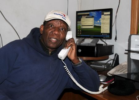 A staff member of a Haitian Radio station answers the phone from a listener in the studio in New York, the United States, Jan. 15, 2010. The radio station helps Haitian in New York to find their relatives and friends by linking with radio station in Haiti. (Xinhua/Cao Yiming) 
