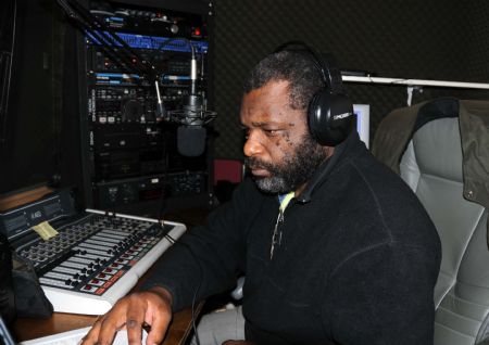 A staff member of a Haitian Radio station listens to an audience in the studio in New York, the United States, Jan. 15, 2010. The radio station helps Haitian in New York to find their relatives and friends by linking with radio station in Haiti. (Xinhua/Cao Yiming)