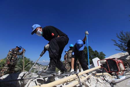 peacekeepers work on the remains of a building in Port-au-Prince, capital of Haiti, Jan. 15, 2010. (Xinhua/Xing Guangli)