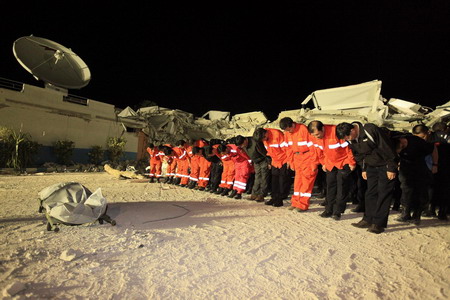 The Chinese rescue team members and the Chinese peacekeepers stand in silent tribute for the Chinese victim whose body was found among the rubble of the collapsed building of the UN Stabilization Mission in Haiti (MINUSTAH) destroyed by Haiti's massive earthquake in Port-au-Prince January 16, 2010.