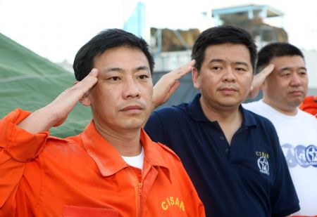 Liu Xiangyang (L), deputy chief of the National Earthquake Disaster Emergency Rescue Team, salutes to a Chinese victim in Port-au-Prince, capital of Haiti, on Jan. 16, 2010. The bodies of all eight Chinese police officers who were buried during the Haiti quake had been found as of early Sunday morning Beijing time, the Ministry of Public Security said. (Xinhua/Yuan Man)