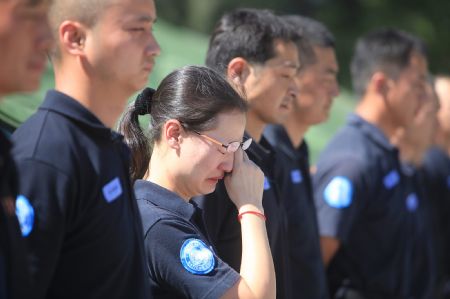 Chinese peacekeeping police wait for the return of their buried colleagues in Port-au-Prince, capital of Haiti, Jan. 16, 2010. Six bodies of eight Chinese peacekeeping police buried in the debris of Haitian earthquake have been found by the press time. (Xinhua/Xing Guangli)