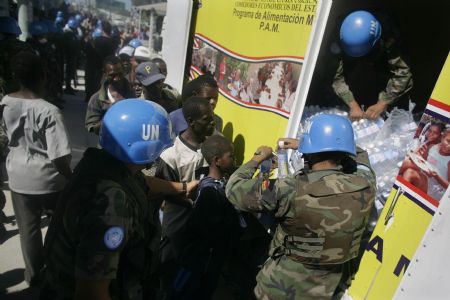 United Nations peacekeepers distribute bottles of water to locals in Haitian capital Port-au-Prince on January 16, 2010. 