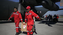 Mexican rescuers unload relief goods from a cargo plane in Haitian capital Port-au-Prince on January 16, 2010. International rescuers are rushing to Haiti following a devastating earthquake on January 12.