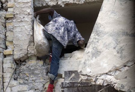 A looter tries to enter a destroyed building in Haitian capital Port-au-Prince on January 16, 2010. 
