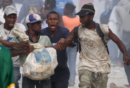  Looters fight for a bag of materials in Haitian capital Port-au-Prince on January 16, 2010. 