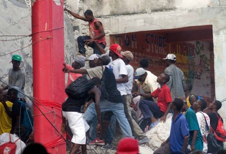 Looters try to enter a destroyed building in Haitian capital Port-au-Prince on January 16, 2010. 