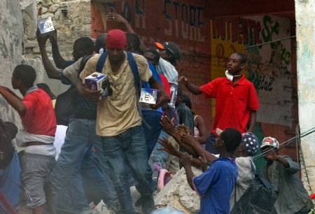 Locals loot products from a destroyed building in Haitian capital Port-au-Prince on January 16, 2010.