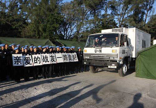 Chinese police officers, holding placards reading &apos;Dear comrades, have a nice trip home&apos; in Chinese, bid farewell to their colleagues who died in the Haiti quake in Port-au-Prince, capital of Haiti, January 17, 2010.