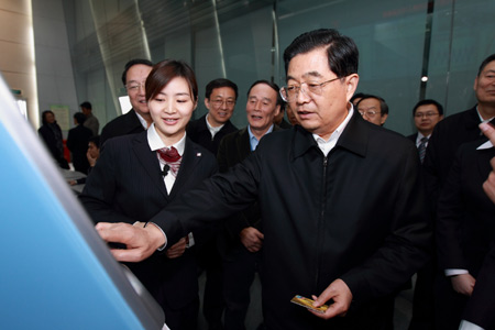 Hu Jintao (front), general secretary of the Central Committee of the Communist Party of China, Chinese president and chairman of the Central Military Commission, tries the bankcard service of China Unionpay (CUP) as he inspects CUP in Shanghai, east China, on January 2010. 