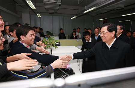 Hu Jintao (R front), general secretary of the Central Committee of the Communist Party of China, Chinese president and chairman of the Central Military Commission, shakes hands with young members of the research and development team as he inspects Spreadtrum Communications, Inc., in Shanghai, east China, on January 16, 2010.