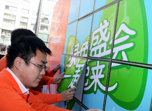 Volunteers patch up a pasteboard promoting the ecological 2010 Shanghai World Expo at the Century Square in Shanghai, east China, January 17, 2010.