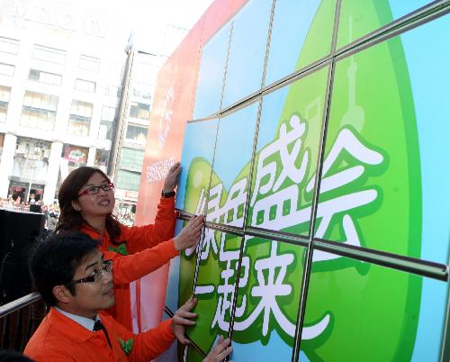 Volunteers patch up a pasteboard promoting the ecological 2010 Shanghai World Expo at the Century Square in Shanghai, east China, January 17, 2010.