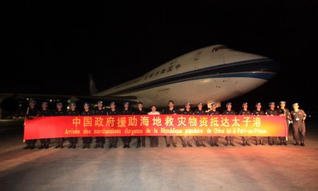 A group of Chinese personnel greet the rescue and relief goods from China at the airport in Port-au-Prince, Haiti, on Jan. 17, 2010. The goods weigh about 90 tons, and are worth about 13 million Chinese yuan(about 1.9 million U.S. dollars), including drugs, tents, portable lamps, water purifying equipments, food and water, and clothing. (Xinhua/Xing Guangli)