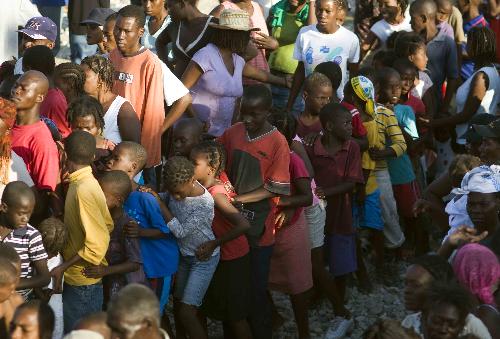 Earthquake survivors walk with relief goods in Port-au-Prince, Haiti, on January 17, 2009.