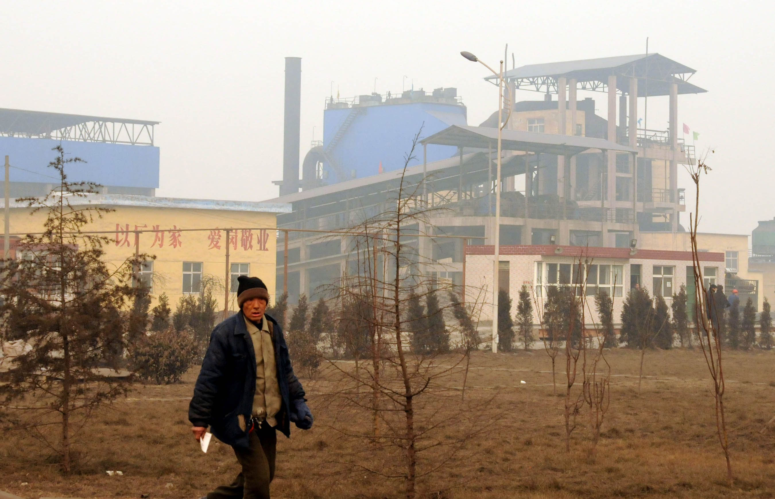 A worker walks in the Shunda Iron and Steel Co., Ltd. in Neiqiu County, north China's Hebei Province, January 18, 2010.