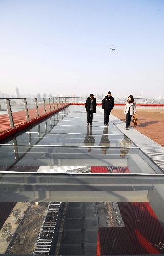 Three persons walk on the newly-completed suspending sightseeing corridor on the overstorey of the China Pavilion of the 2010 Shanghai World Expo, in Shanghai, east China. 