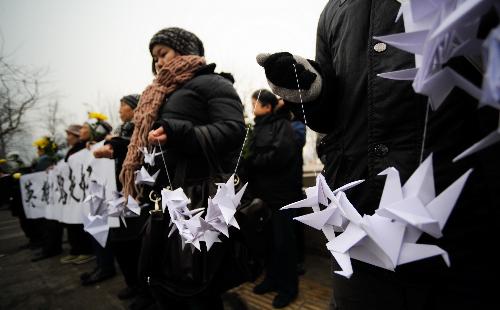 Mourners wait for the arrival of the coffins of the eight peacekeeping police officers who were killed in the Haiti earthquake in a crossing linking to the Babaoshan Revolutionary Cemetery in Beijing, January 19, 2010. 