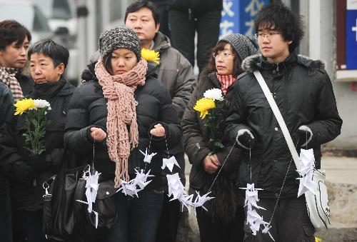 Mourners wait for the arrival of the coffins of the eight peacekeeping police officers who were killed in the Haiti earthquake in a street leading to the Babaoshan Revolutionary Cemetery in Beijing January 19, 2010. 