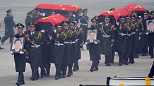 Soldiers carry the coffins of the eight peacekeeping police officers who died in the Haiti earthquake at the airport in Beijing, China, January 19, 2010.
