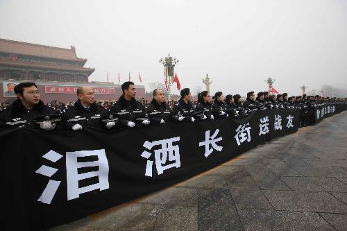 The police and mourners bid farewell to the coffins of the eight peacekeeping police officers who were killed in the Haiti earthquake at the Chang'an Street in Beijing, China, January 19, 2010.