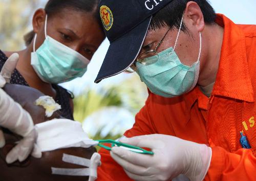 A medic of China International Search and Rescue Team (CISAR) redresses the wound for an earthquake survivor in Port-au-Prince, Haiti, on January 17, 2010. 
