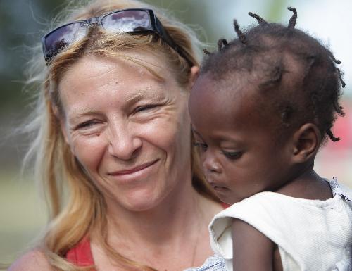 A French teacher hugs a child in an orphanage in Port-au-Prince, capital of Haiti, January 19, 2010. 