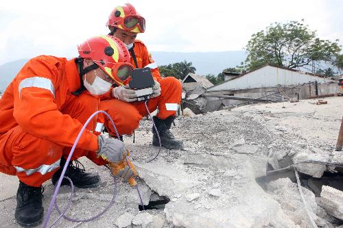 Members of China International Search and Rescue Team (CISAR) search for survivors on debris near a destroyed supermarket in Port-au-Prince, Haiti, January 19, 2010. 