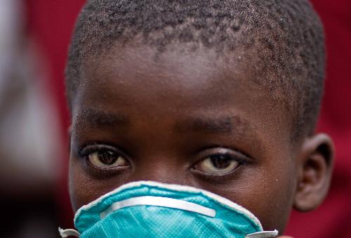 A local kid wears a mask to prevent the odorous smell in Port-au-Prince, Haiti, January 18, 2010. 