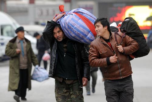 Passengers walk out from Beijing West Railway Station in Beijing, China, January 20, 2010. 