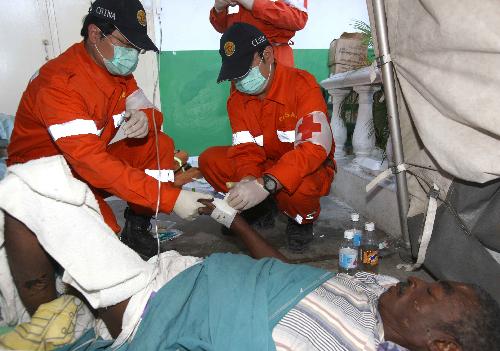 Members of China International Search and Rescue Team dress a wound for a Haitian man in Port-au-Prince January 20, 2010.