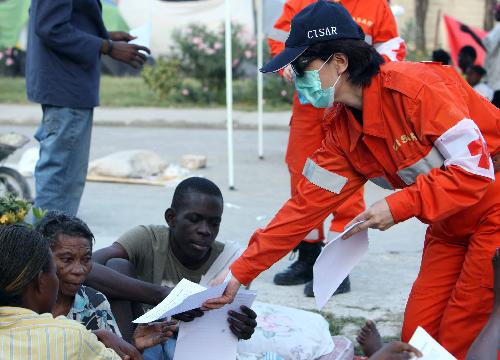 A member of China International Search and Rescue Team distributes pamphlets on sanitation and epidemic prevention to Haitian people in Port-au-Prince January 20, 2010. 
