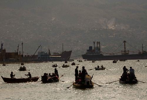 Local citizens try to flee this destroyed city by boat in Port-au-Prince, Haiti, January 20, 2010. 
