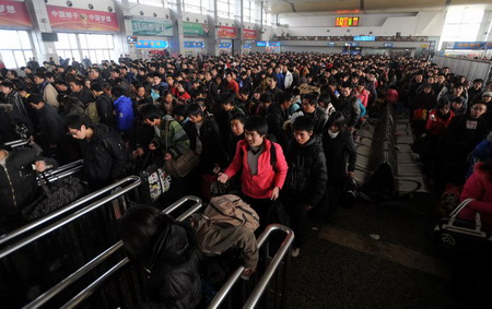 Passengers line up as they wait to board a train at a railway station in Chengdu, Sichuan province January 20, 2010. 