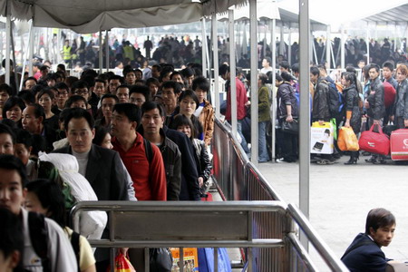 Passengers line up as they wait to board a train at Guangzhou Railway Station in Guangzhou, Guangdong province January 20, 2010.