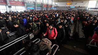 Passengers line up as they wait to board a train at a railway station in Chengdu, Sichuan province January 20, 2010.