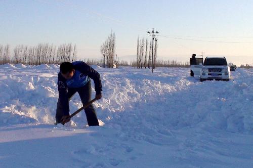 A man clears snow along a road in Tacheng, northwest China's Xinjiang Uygur Autonomous Region, January 21, 2010.