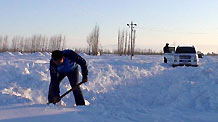 A man clears snow along a road in Tacheng, northwest China's Xinjiang Uygur Autonomous Region, January 21, 2010.