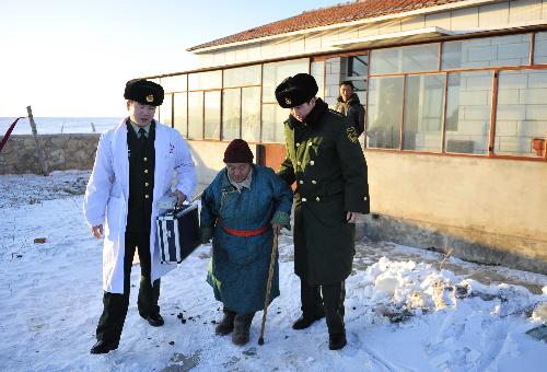 Medical officers from a Chinese border police station offers a woman help after giving her a health checkup in Xilingol, north China's Inner Mongolia Autonomous Region, January 21, 2010. 