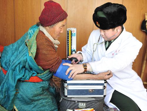 A medical officer from a Chinese border police station offers a local herdsman health checkup in Xilingol, north China's Inner Mongolia Autonomous Region, January 21, 2010. 