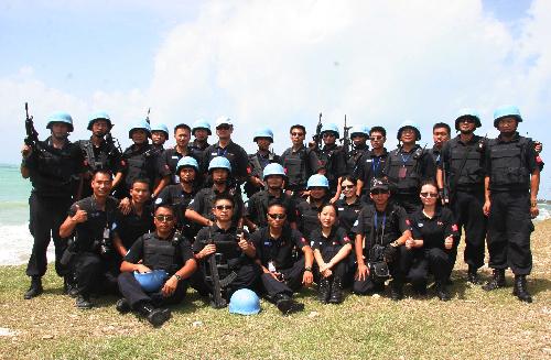 This file photo shows members of Chinese formed police unit in Haiti pose for a group photo after duty in Port-au-Prince, Haiti. In October 2004, China sent the first group of formed police unit of 125 people to Haiti.