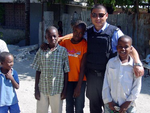 Guo Hui (C), a member of Chinese formed police unit in Haiti, poses with local children in Port-au-Prince, Haiti, January 17, 2010.