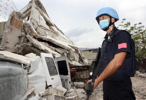 Li Wenlong, a member of Chinese formed police unit in Haiti, stands guard in one of the most destroyed districts in Port-au-Prince, Haiti, January 19, 2010.