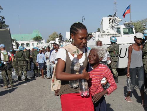Residents get bottled water at an aid distribution site in Port-au-Prince, capital of Haiti, on January 22, 2010, 10 days after a catastrophic earthquake hit the nation on January 12.