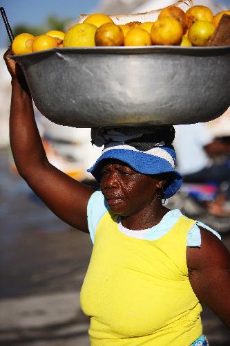 A woman heads up some fruits in a street in Port-au-Prince, capital of Haiti, on January 22, 2010, 10 days after a catastrophic earthquake hit the nation on January 12.