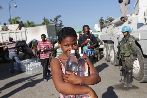 A girl receives bottled water at an aid distribution site in Port-au-Prince, capital of Haiti, on January 22, 2010, 10 days after a catastrophic earthquake hit the nation on January 12.