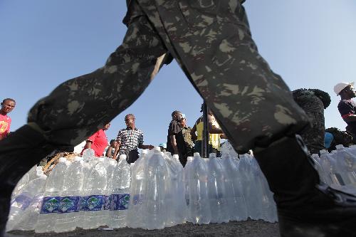 People receive water at an aid distribution site in Port-au-Prince, capital of Haiti, on January 22, 2010, 10 days after a catastrophic earthquake hit the nation on January 12.